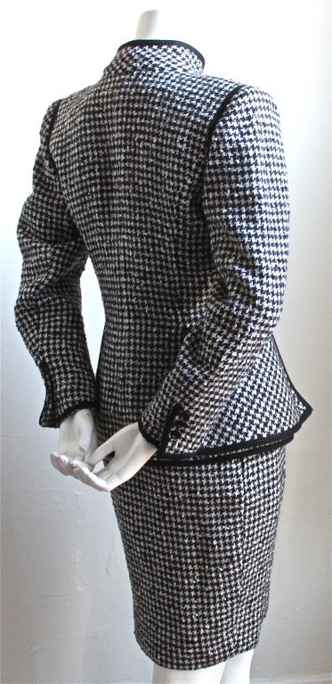 Black and white houndstooth wool suit with peplum and frog closures from Emanuel Ungaro dating to the 1980's. Suit best fits a size 2 or 4. Excellent condition.