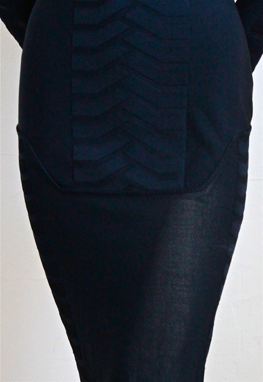 Jet black knit dress with sheer hemline from Thierry Mugler dating to the 1990's. Labeled a size 'M', which best fits a US size 6-8.  Approximate (unstretched) measurements are: shoulder 14