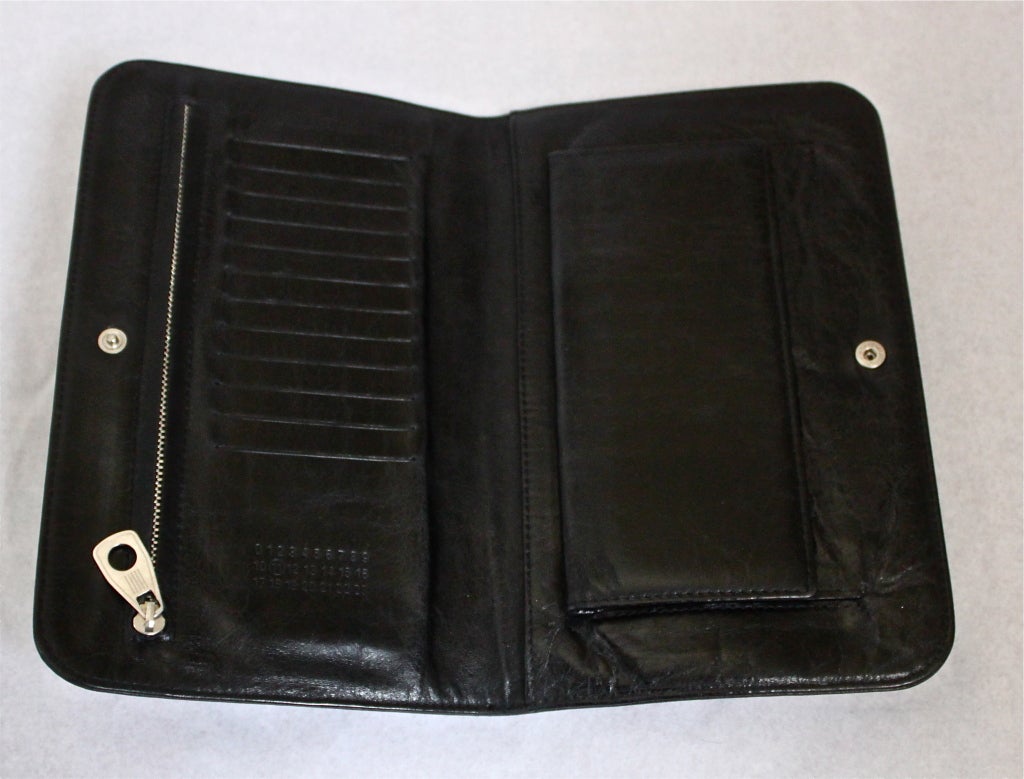 Intentionally distressed shiny jet black leather clutch with glove handle from Martin Margiela (line 11) dating to 2007. Bag measures approximately 8.5