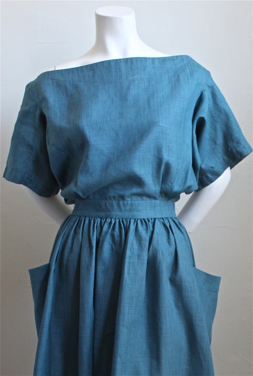Unusual vivid turquoise linen dress with cut out back and wrap around pockets from Azzedine Alaia dating to the mid 1980's. Labeled a French size 42. Approximte measurements are as follows: 27-28