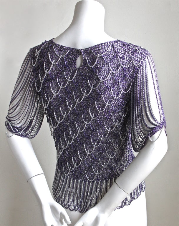 Intricately woven sweater intertwined with chain from Loris Azzaro dating to the 1973. Same style sweater as seen in Helmut Newton photograph. Fits a size XS or S. Slips on over the head and secures with a snap behind the neck. Made in France.