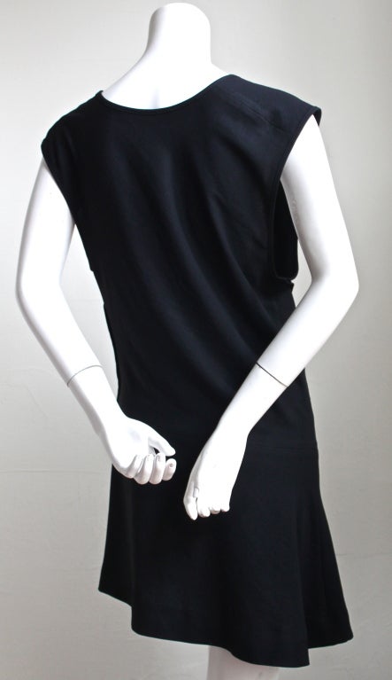 Unique black crepe dress with cut out at front and asymmetrical flanged hem from Comme Des Garcons dating to 1992. Labeled a size 'M'. Made in Japan. Very good condition (has been re-hemmed and resewn at waist).