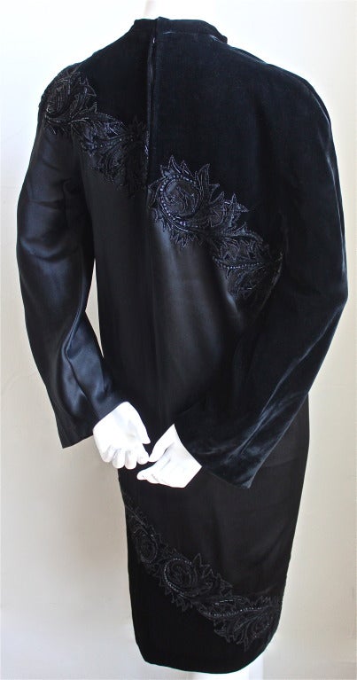 Very rare jet black silk satin and velvet haute couture dress with unique spiral design and elaborate beading designed by Pierre Balmain dating to the 1950's. Dress has a red bow at neckline  which indicates that it was made for a recipient of the