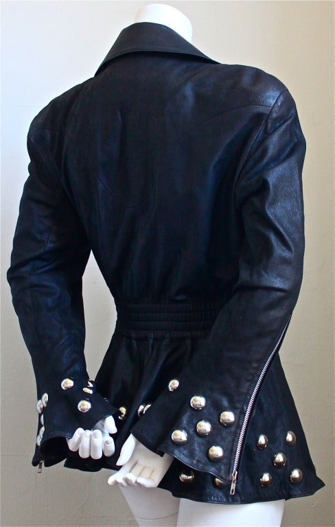 Very unique black leather jacket with oversized round silver studs from Thierry Mugler dating to the 1990's. Jacket is labeled a French size 40, however it is very broad through the shoulders and would best fit a US 8 or 10. Made in France. Very