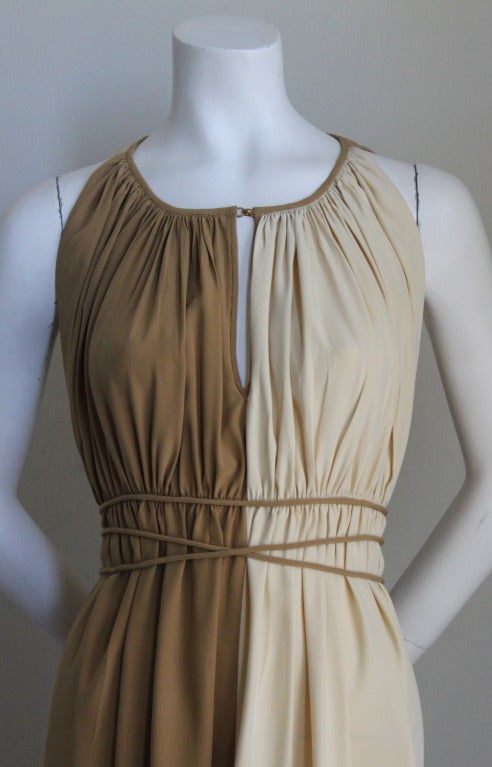 Cream and tan Grecian style silk pleated dress with long waist ties attributed to Claire McCardell. Dress best fits a size 4-6. Approximate length is 43