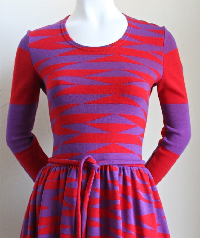 Vibrant red and purple woven op-art knit dress with matching belt from Rudi Gernreich dating to 1971. Although dress is labeled a size 10, it best fits a size S/M. Approximate measurements: bust 33