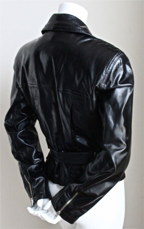 Jet black leather motorcycle jacket with silver hardware and lace up detail at back from Azzedine Alaia dating to the 1980's. French size 40. Measues approximately: shoulder 17