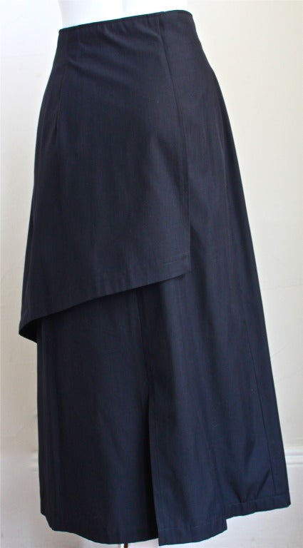 Jet black wool blend wrap skirt with asymmetrical layer designed by Matsuda dating to the late 1980's. Labeled a Japanese Medium. Wrap front with double button closure. Made in Japan. Excellent condition.
