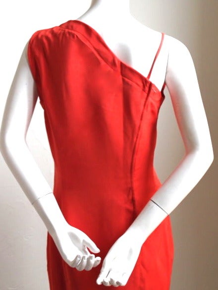 Vivid persimmon-orange, asymmetrically shaped dress from Thierry Mugler dating to the 1990's. French size 40. Approximate measurements: bust 36