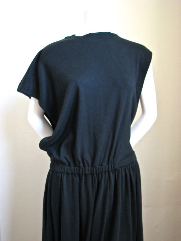 Very unique asymmetrically cut 'Comme des garcons tricot' dress. Gathered, elasticized waist band. Open sides at bodice. Slash pockets at hips. Made of 100% cotton mid weight jersey. Color is black. Best suited for a medium. Made in Japan. Excellent