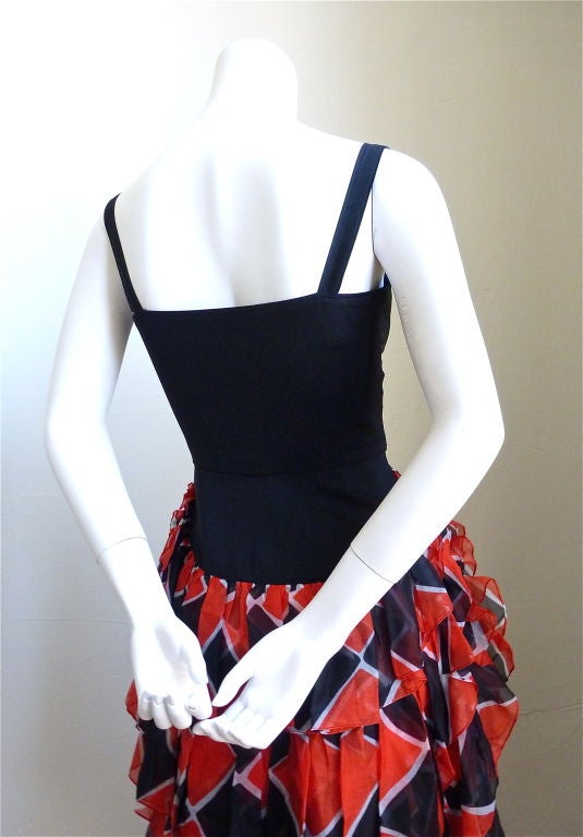 Very unique evening dress with tiered harlequin print silk from Yves Saint Laurent rive gauche dating the the late 1980's. Colors are jet black, red, and white. Bodice buttons up at center front with large black buttons. French size 36. Best suited