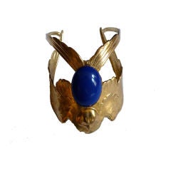 Gilt eagle cuff with blue glass cabachon