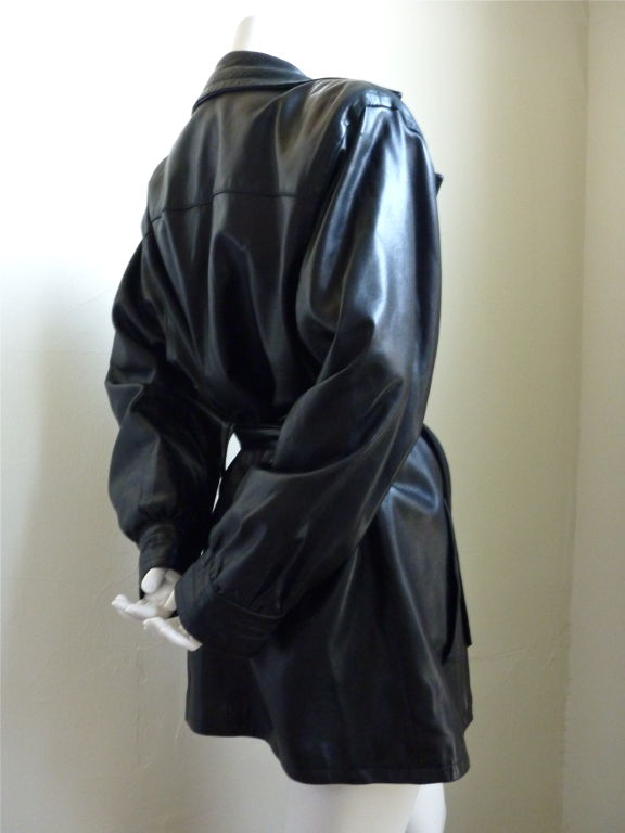 Butter soft black leather jacket from Yves Saint laurent. Ca. 1985. Labeled a French size 42; best suited for a US size 8-12. Large notched collar, strong shoulders, and full arms. Large, wide belt. Buttons up front. Pockets at hips. Fully lined.