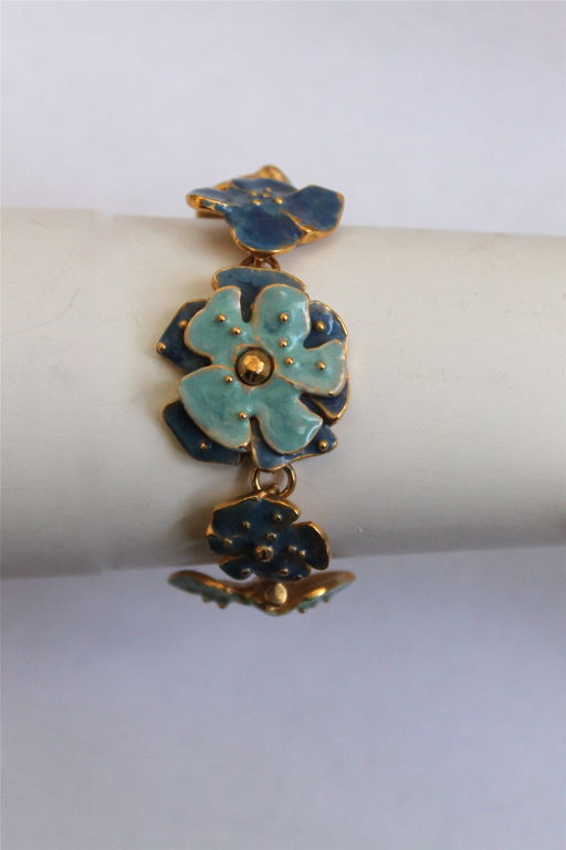 Beautifully detailed gilt metal floral bracelet with enamel from Jean-Louis Scherrer. Ca. 1985. Varying shades of blue. Fits a small wrist. Toggle closure. Very good condition with just a tiny portion of the enamel missing.