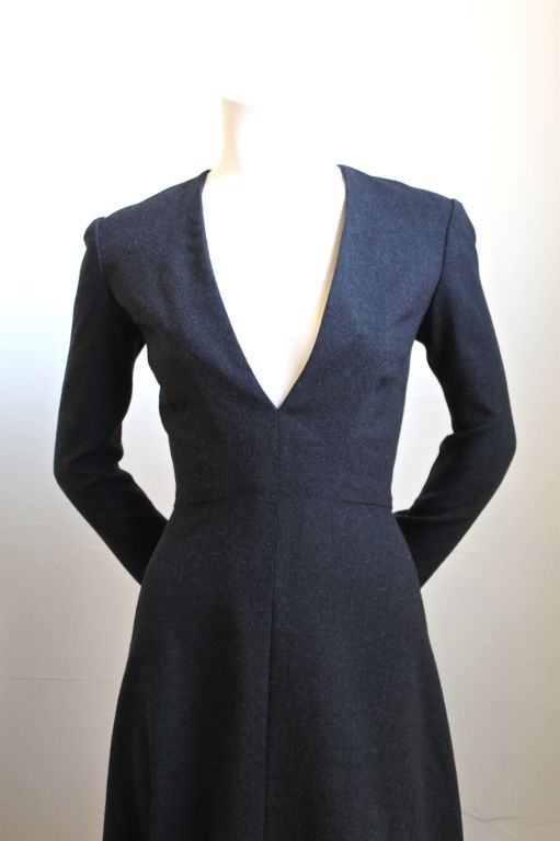 Classic yet daring dress with deep V neckline from Pauline Trigere. Charcoal in color. Dress has a flattering A line shaped shirt portion which elongates the body. Fits a US 6-8. Zips up center back. Zips at wrists. Fully lined in silk. Excellent