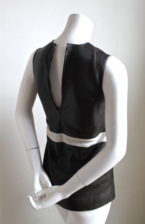 Very rare deep brown leather tunic with white geometric accent at waistline from Pierre Cardin dating to the 1960's. This is a very small tunic/mini dress. It fits a 30
