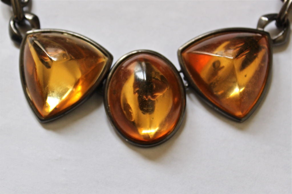 Gunmetal and soft amber colored resin. Adjustable closure. Made in France. Very good condition.
