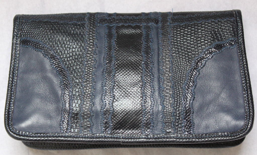Navy blue patchwork clutch made of reptile skins from Carlos Falchi dating to the 1980's. Bag measures approximately 9