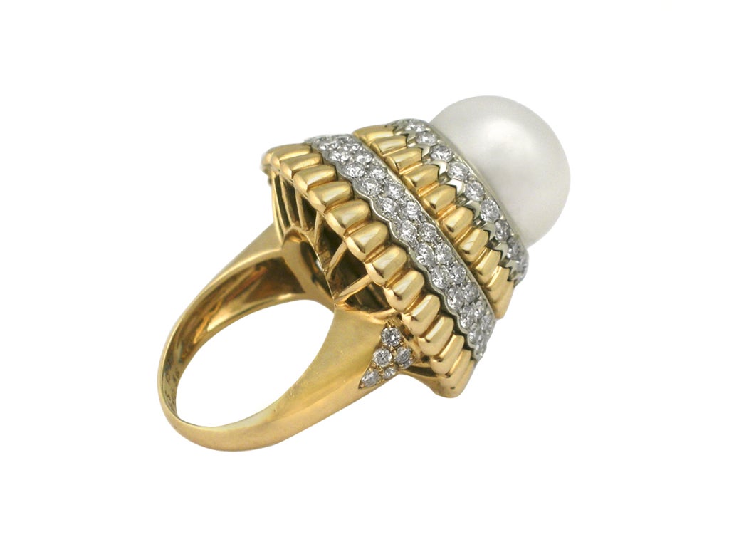 18 kt. gold ring centering an approx. 13 mm cultured pearl, circled by alternating layers of pave' diamonds and gold 