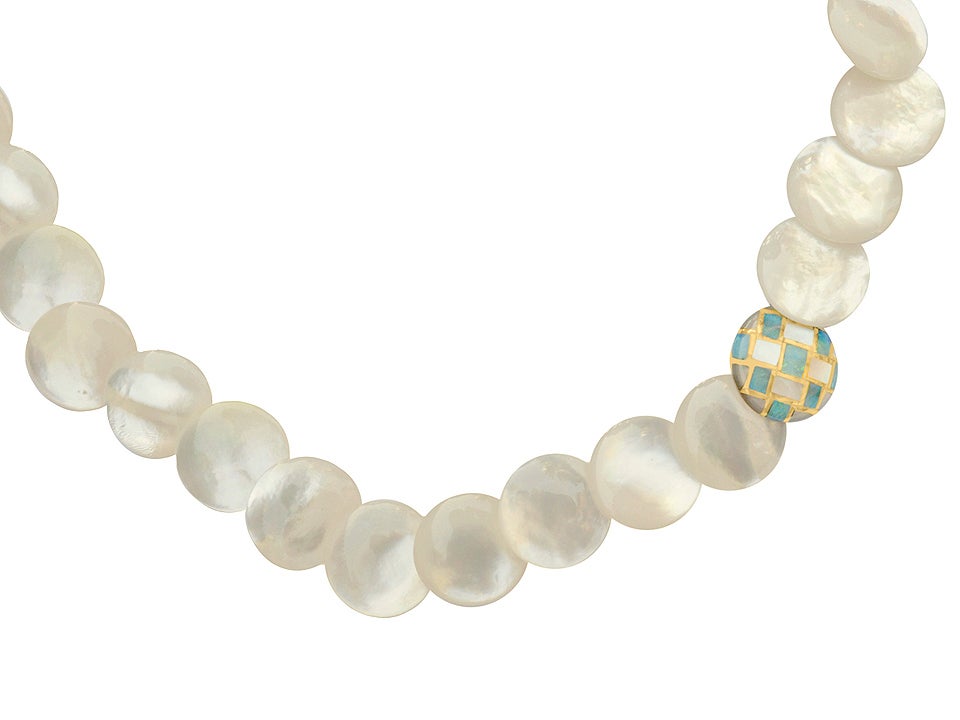 Necklace consisting of mother of pearl buttons, with one inlaid mother of pearl and opal disc. 18kt gold clasp. Signed Tiffany & Co.