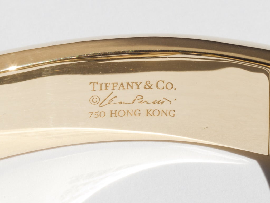 18k hinged, gold cuff with a heart-shaped carved lapis terminal ,
signed ELSA PERETTI, TIFFANY & CO., Hong Kong.