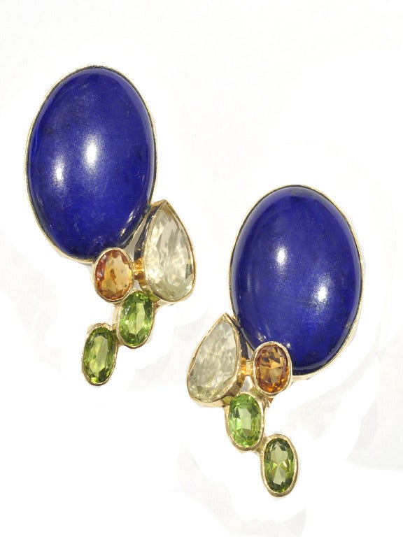 18 kt. gold earclips, centering large oval lapis cabochons, edged by 2 oval yellow citrines, 2 orange citrines, and 4 oval peridots. With maker's mark and Trench essay marks.