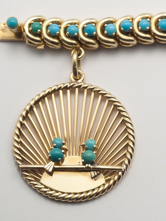 18 kt. gold and turquoise charm bracelet with  an  openwork 