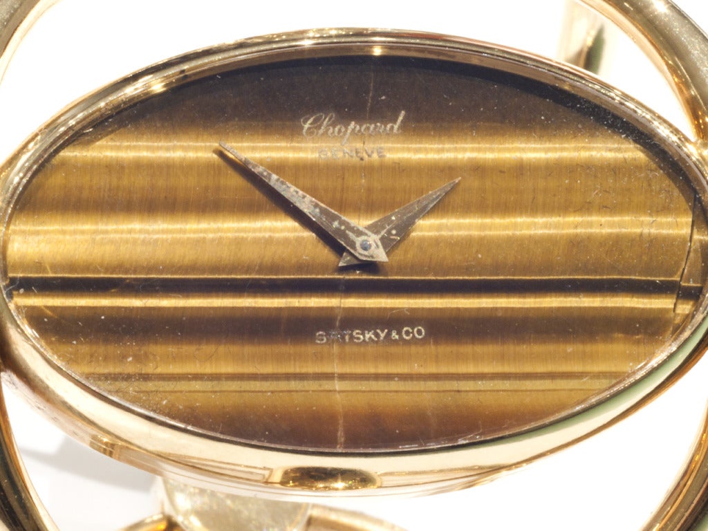 18k yellow gold bracket watch with fold-over clasp, tiger's eye dial. Manual-wind movement. Signed and numbered.