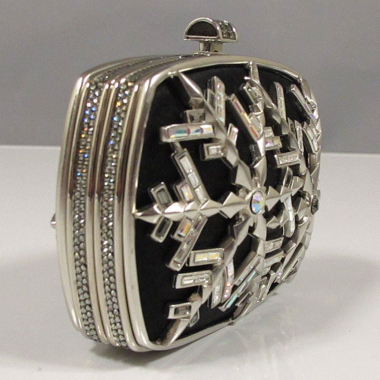 Judith Leiber vintage small minaudiere composed of jet black silk, clear, iridescent and smoky gray crystals and silver-tone metal casing. Crystal-encrusted trimmings and push tab opening.  Optional silver chain strap. Black silk lined interior with