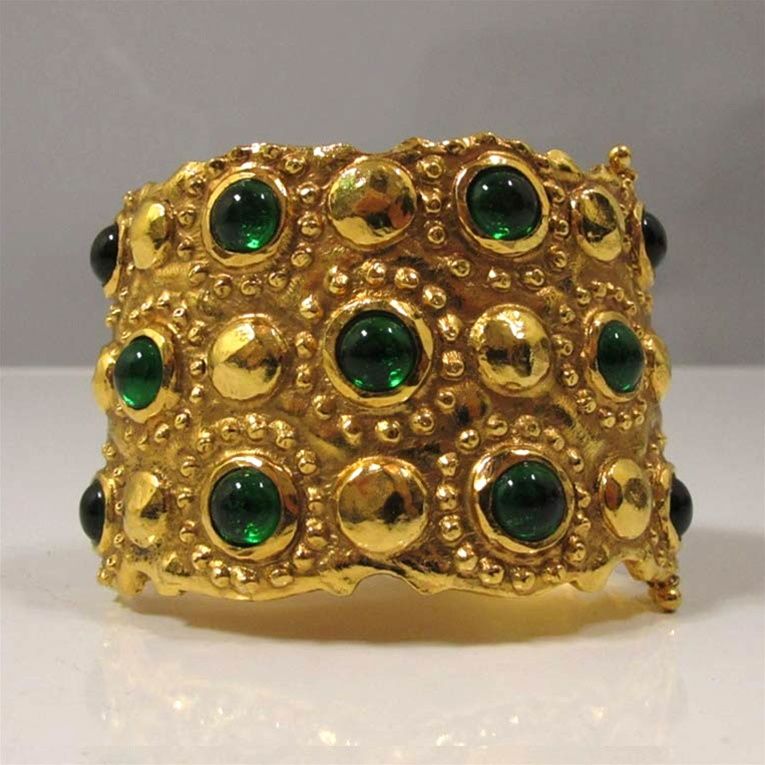 CHANEL circa mid-1980s textured gold-tone metal cuff with bezel set emerald gripoix stones.  The cuff has a hinge closure and two safety locks.  Adds a touch of sophistication and CHANEL charm to any outfit. A great simple accessory for holidays.