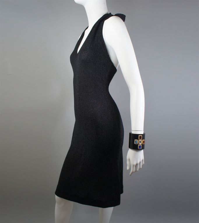 Halston 1970s vintage halter dress of black metallic lurex in a classic soft, body-hugging Halston design. This very simple silhouette has a v-neck and ties on the back of the neck (can be styled in a bow, as seen here, or loosely tied). A great LBD