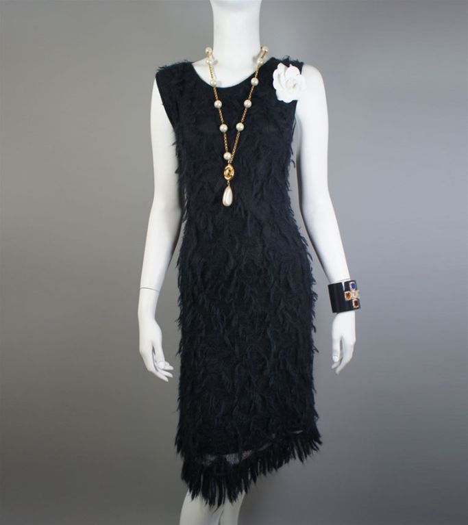 This Chanel 09A mohair blend, fringe dress has a classic round neckline and a-line cut. It is fully lined with a silk and elastic blend. The fringe mohair at the bottom hem and black CC charm on the bottom left complete the look. The sleeveless