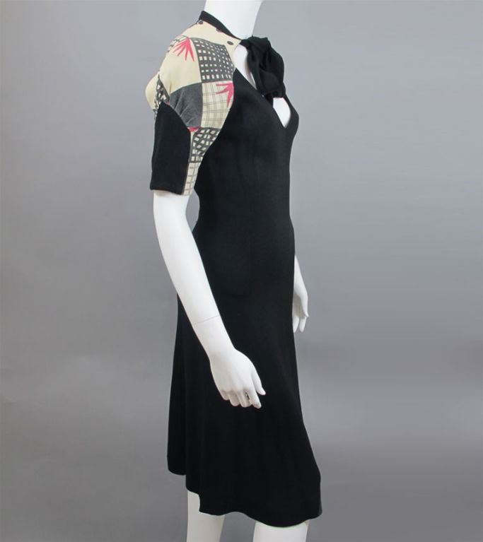 Vintage Ossie Clark Celia Birtwell Print 1960's dress. Black body with scooped neckline featuring a tie color and shrug style sleeves with geometric patterned tan, black and pink sleeve print.  The interior back neck has the original tag 