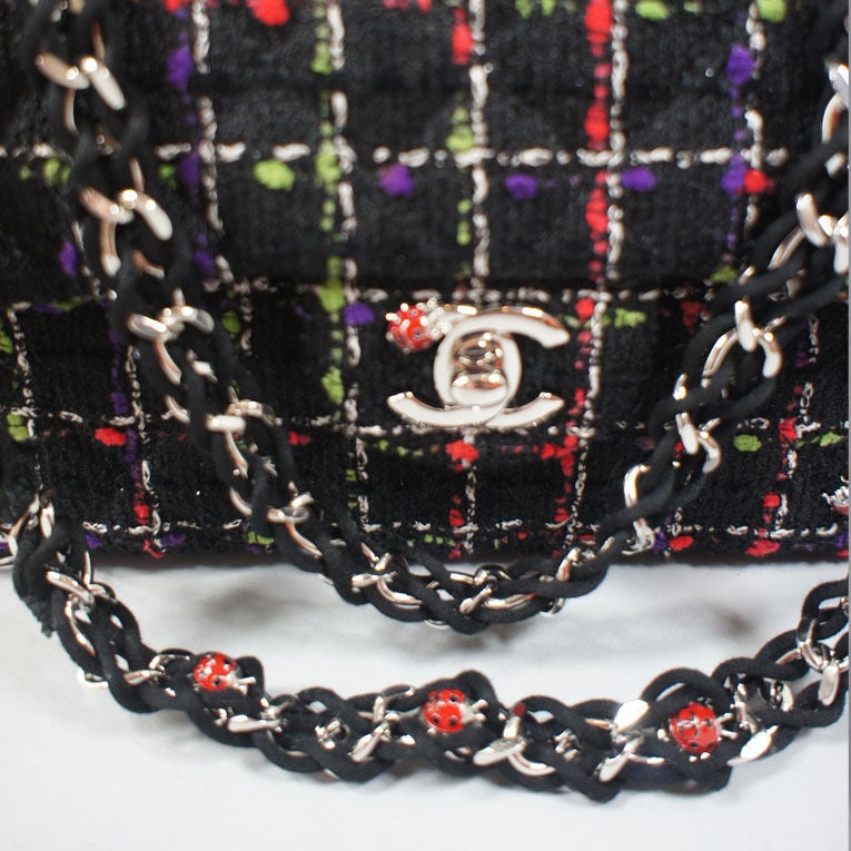 Chanel classic flap ladybug bag in tweed with silver tone hardware. This unique multi colored bag is sold out and impossible to find due to its popularity. The wool tweed has red, green, white, and purple colors throughout and is embellished with