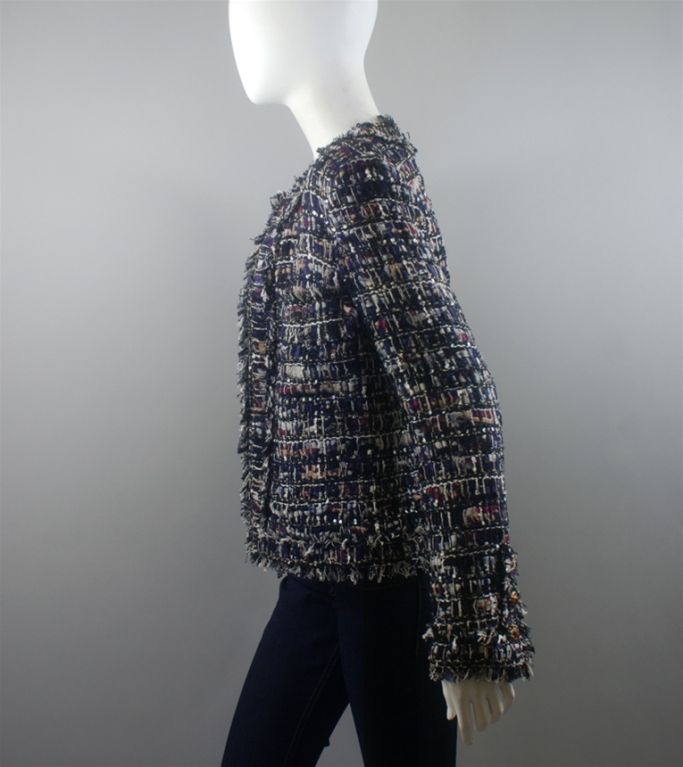 CHANEL 10A multi boucle jacket in navy, maroon, and white with fringe and sequin detail, and silver lurex throughout . The front has a round neck, and hook and eye closures.  There are two breast pockets with the same fringe trim as the collar,