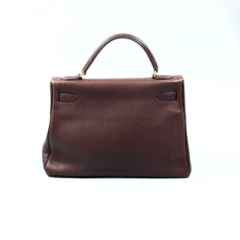 Hermès chocolate (brown) Fjord leather Kelly handbag in 32cm with shiny gold hardware, matching strap, clochette, lock (2 keys) and shoulder strap. This subtle natural color chocolate bag is a great neutral to wear this season, stamped V in a circle