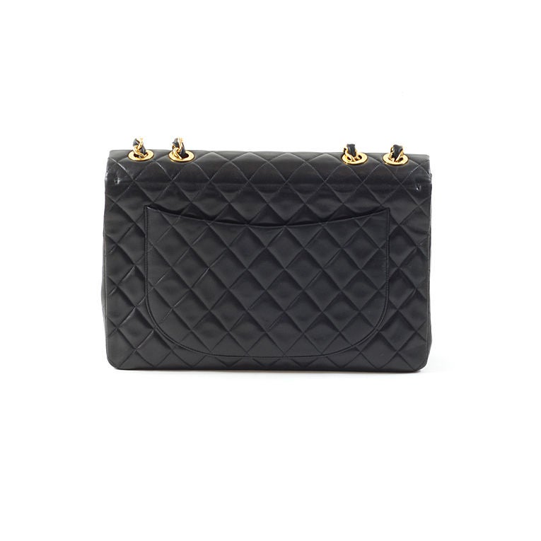 CHANEL iconic vintage black lambskin jumbo classic flap in XL size with gold-tone hardware. This Chanel forever favorite features a CC turnkey lock on front flap and half moon back slip packet. The signature chain strap can be pulled through and