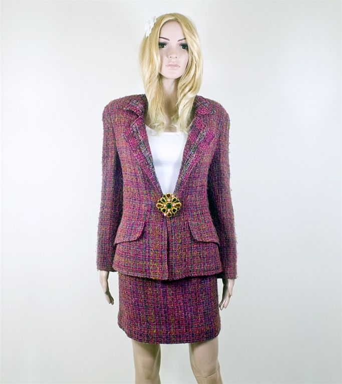 Chanel 98A dark red and multi colored fantasy tweed skirt suit. This suit is a mixture of red, pink, forest green, and olive all woven into a fantasy tweed. The jacket has two front hip pockets with flaps and the sleeves have three translucent CC