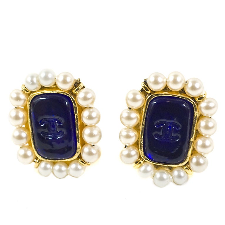 CHANEL vintage sapphire (blue) gripoix stone earrings with CC design on gold-tone metal surrounded by faux pearl trim from the 94A collection. Clip-on with the back of the earring stamped Chanel 94A, Made in France. A classic Chanel look to enhance
