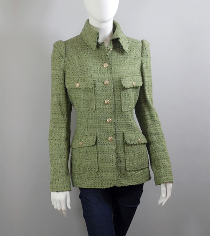 CHANEL green and multi tweed jacket with black throughout. The jacket has six front buttons along the closure, two breast pockets and two hip pockets that button close.  Long sleeve with three button on each cuff. The back has a slit that is closed