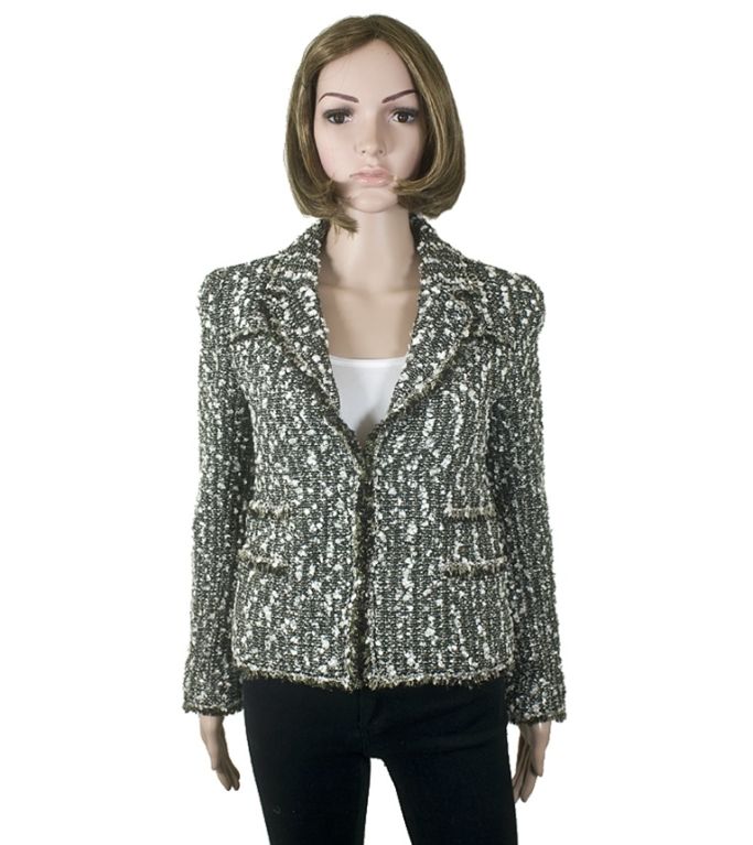 This Chanel 04A black and white fantasy tweed jacket has accents of olive and silver metallic threading throughout. Details like eyelash fringe and sweet bow buttons make this open jacket a special addition to your closet.<br />
<br />
Chanel 04A