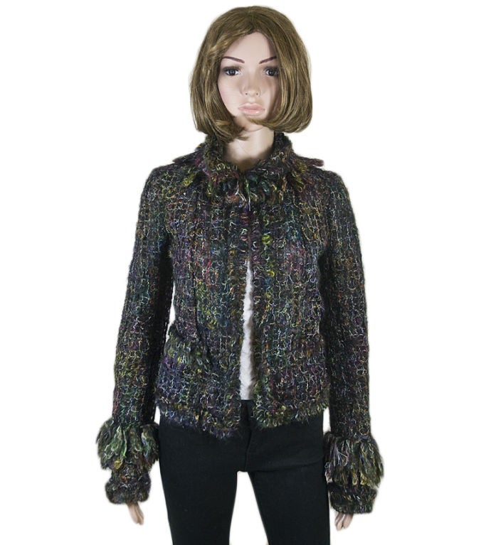 This Chanel boutique fantasy tweed jacket is intricately detailed with rainbow boucle tweed over a shell of delicate mesh.  Bold looped fringe at the collar and cuffs ensure that you’ll stand out wherever you go in this bright piece.  Pair with