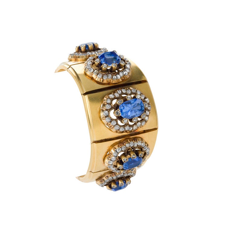 A French Antique 18 karat gold bracelet with blue sapphires and diamonds by Mellerio dits Meller. The bracelet features  5 cushion-cut blue sapphires with each sapphire having an approximate weight of 2.80 carats, 5.20 carats,  6.05 carats,  3.05