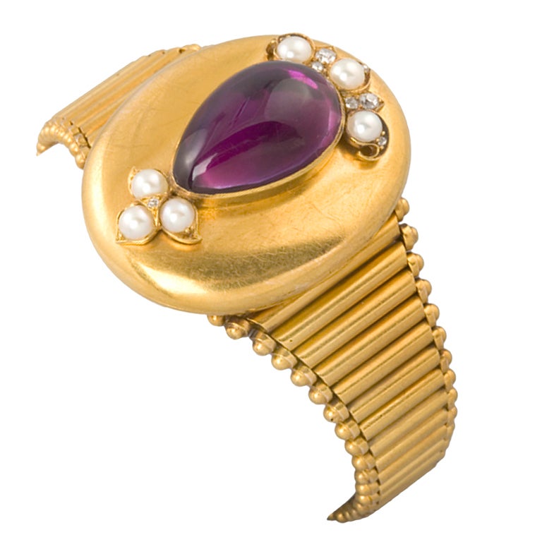 A Victorian 18-karat gold, amethyst and pearl bracelet, featuring a center pear-shaped cabochon amethyst, eight old mine-cut diamonds with the approximate total weight of .18 carat and six seed pearls. The bracelet top is a double frame locket.