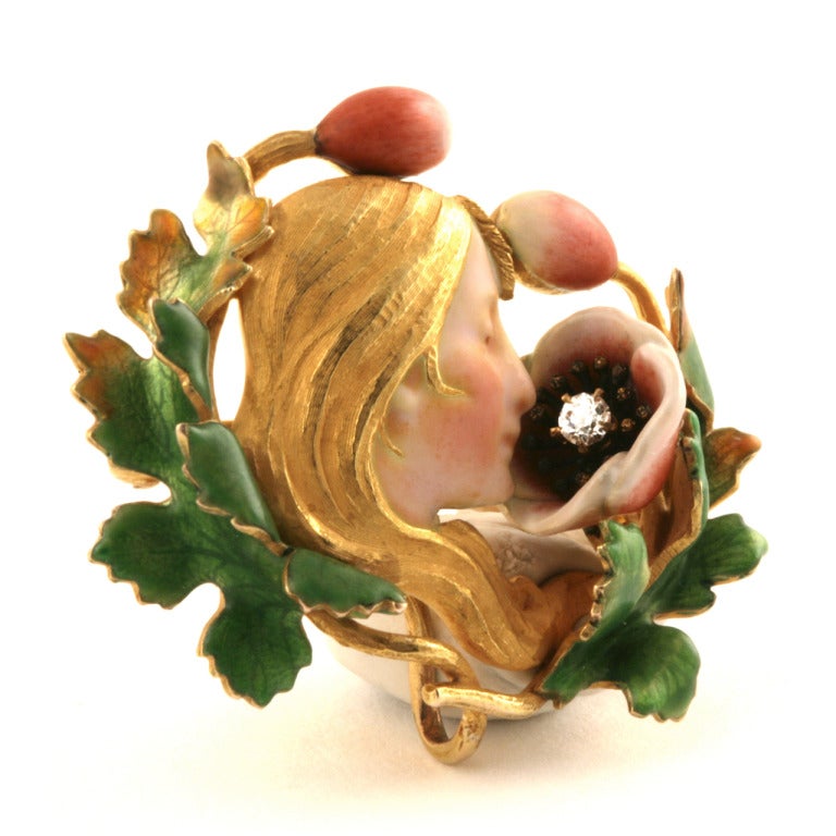An American Art Nouveau 14 karat gold and enameled brooch with diamond by Krementz & Co. The brooch has one old mine-cut diamond sitting within an open rose, with an approximate total weight of .05 carats. This romantically inspired brooch portrays