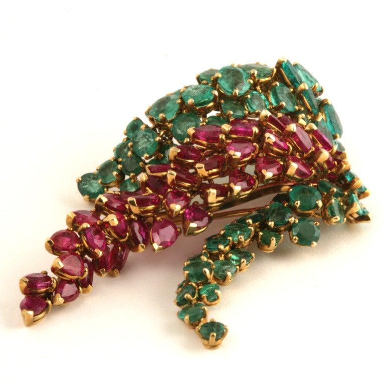 A French Mid-20th Century 18 karat gold brooch with rubies and emeralds by Marchak.The brooch has 44 rubies with an approximate total weight of 14.00 carats, and 72 emeralds with an approximate total weight of 9.60 carats.The grape cluster motif has