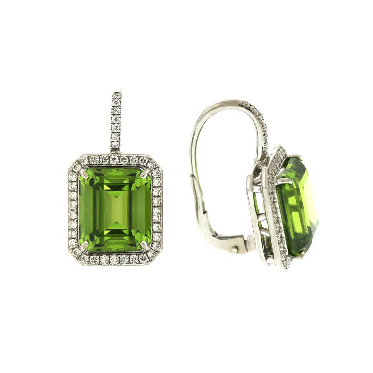 Generously sized 10.66cts Emerald Cut Superb Color & Quality Peridot set in a diamond pave frame on lever backs.