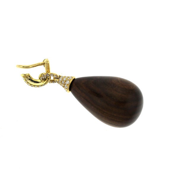 Natural Nut Wood high polished drops have a subtle light and dark grain and are suspended from 108 round G, VS diamonds in 18K yellow gold. Clips.