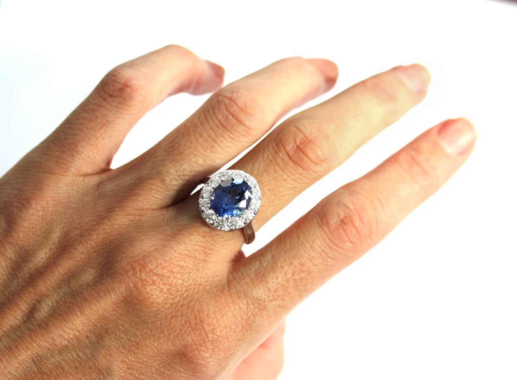 A magnificent 4.21 carat vivid violet-blue oval Tanzanite classically set in a frame of round brilliant diamonds in platinum. Size 7.  Can be sized.
