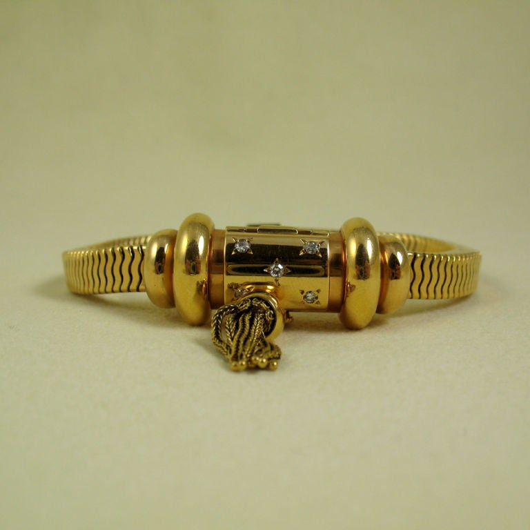 The dial concealed in a cylinder, enhanced by star-set brilliants and a tassel, mounted in 18k yellow gold, with French assay mark, circa 1940, signed 